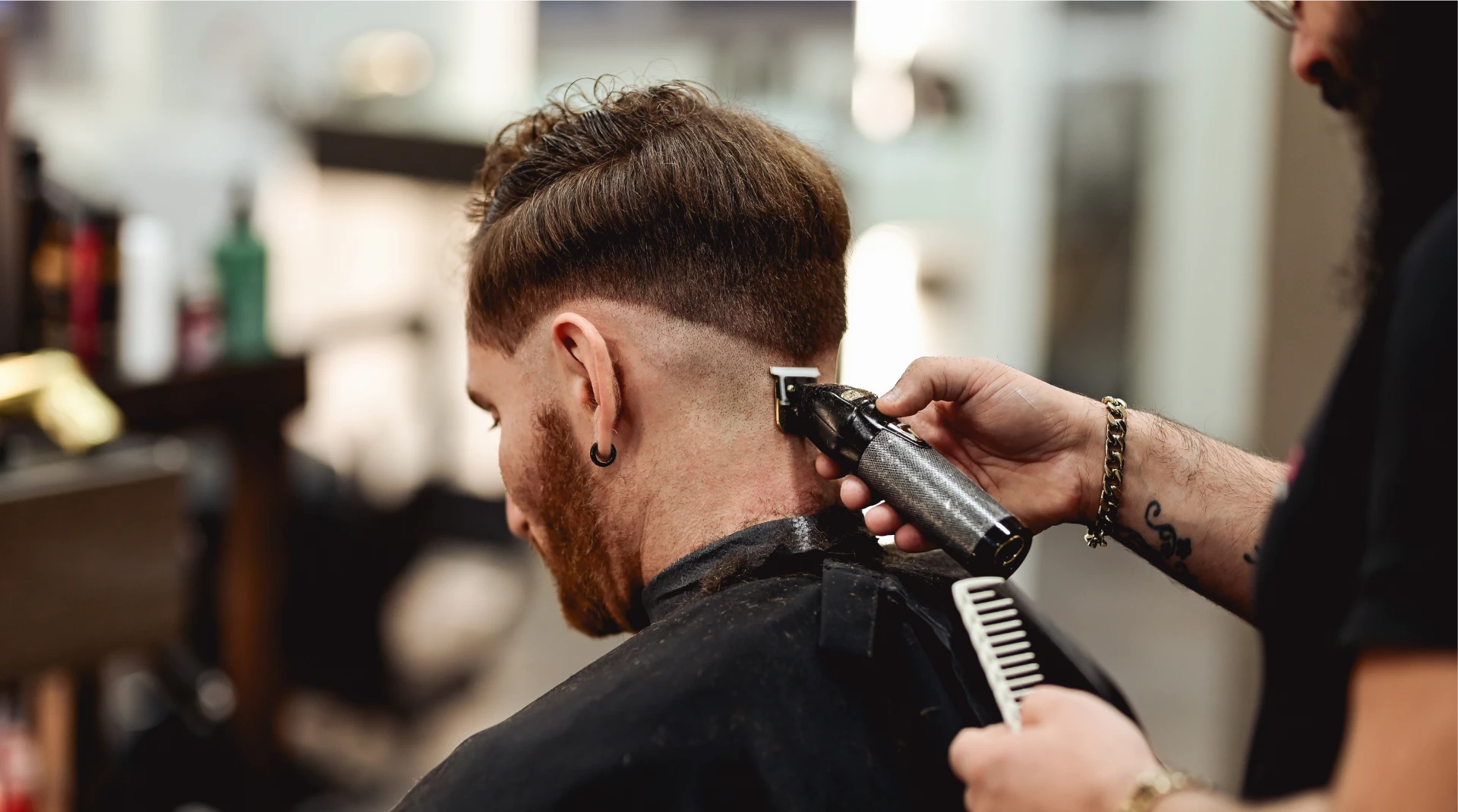 Man getting his hair cut by a barber in a barbershop