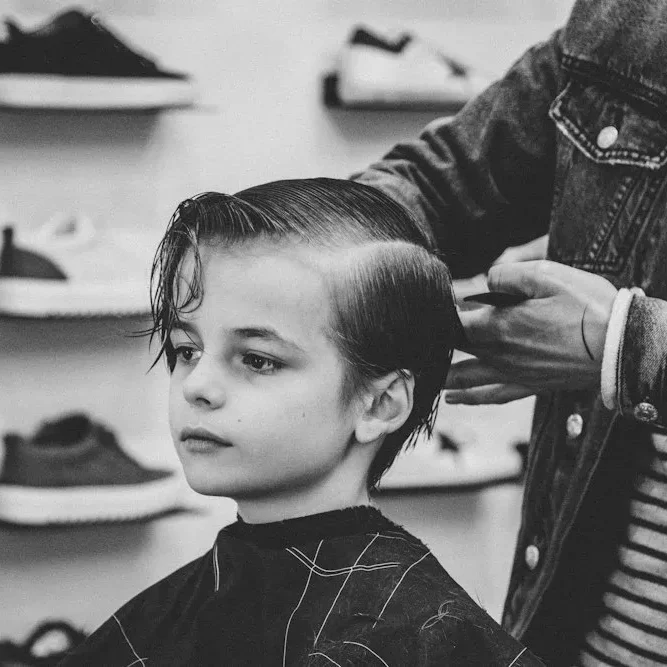Black-and-white photo of a barber cutting a client's hair