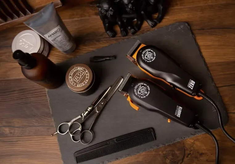 Barber tools and grooming products arranged on a dark countertop